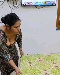 a woman cutting up a quilt on top of a bed