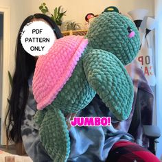 a woman holding up a stuffed turtle in her arms with the caption pop pattern only jumbo