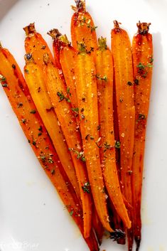 cooked carrots on a white plate with seasoning