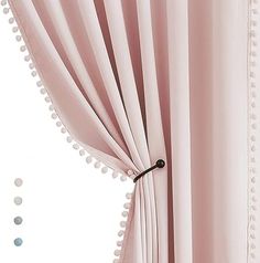 a pink curtain with pom - poms hanging from it's side, in front of a white background