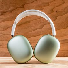 two green headphones sitting on top of a wooden table