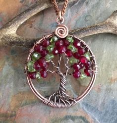 This unique & gorgeous wire wrapped Tree of Life pendant necklace. The pendant is made with deep red Garnet & Peridot gemstone using antiqued copper wires. The pendant measures about between 1.35 to 1.40 inch  in diameter. It comes with your choice of an antiqued copper finished chain, Deerskin Lace leather or genuine black leather necklace Each pendant is handmade, so please allow slight variations from the shape of the branches and placement of the stones as shown. The Tree of Life is a universal symbol found in many spiritual traditions around the world. The tree of knowledge, connecting to heaven and the underworld, and the tree of life, connecting all forms of creation, are both forms of the world tree or cosmic tree. It's meaning represents life itself, wisdom, love, strength, protec Red Hand Wrapped Jewelry Gift, Hand Wrapped Red Jewelry For Gift, Red Wire Wrapped Copper Jewelry, Red Copper Wire Wrapped Jewelry, Hand Wrapped Wire Necklaces For Gifts, Hand Wrapped Wire Necklace For Gift, Red Hand Wrapped Necklace As Gift, Hand Wrapped Red Necklace As Gift, Red Hand Wrapped Necklace For Gift