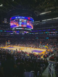 a basketball game is being played in an arena with people sitting on the sidelines