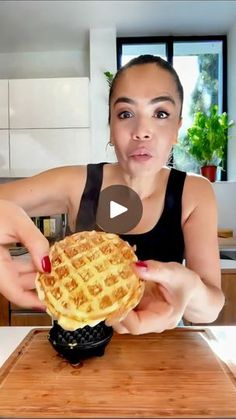 a woman is holding a waffle in her hands