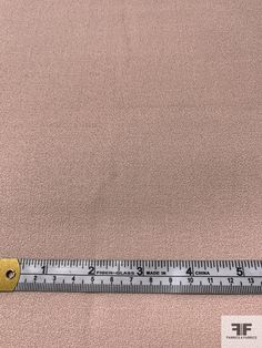 a ruler is on the ground next to a piece of fabric