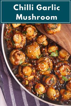 a pan filled with mushrooms and sauce on top of a purple cloth next to a wooden spoon