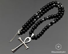 Ankh Cross Necklace Natural Black Onyx Beaded Necklace Stress Crystal Gemstone Strong Clasp Necklace Anxiety Necklace -ALL THE PRODUCTS AT ELISAJEWELRYART ARE HANDMADE AND MADE WITH NATURAL BEADS. -WHAT DOES THE ONYX STAND FOR    A powerful protection stone, Black Onyx absorbs and transforms negative energy, and helps to prevent the drain of personal energy. Black Onyx aids the development of emotional and physical strength and stamina, especially when support is needed during times of stress, c Cardboard Jewelry, Ankh Cross, Personal Energy, Cardboard Jewelry Boxes, Physical Strength, Clasp Necklace, Protection Stones, Onyx Bead, Gift Pouch