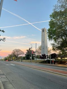 a tall white tower sitting on the side of a road