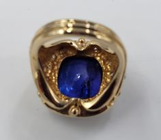 Title: Designer: Unbranded Material:Yellow Gold 14KT Style: Fashion Vintage Gemstone Details All measurements are approximate and may vary slightly from the listed dimensions. Diamonds Stones 18 Round Diamonds 2.3 mm 0.90 CTW Violet- Blue Cushion cut Tanzanite Stone is Cracked through the table 14.3mm/12.3mm/7.5mm 10.67 Cts Estimated Measurements Length/Width/Depth Size 7 US 23.48mm/14.36mm Estimated Total Weight Dwt: 8.6 Grams: 13.3 ConditionUsed Condition- Tanzanite is cracked -Gold is polishe Luxury Collectible Sapphire Ring, Luxury 14k Gold Sapphire Ring Hallmarked, Luxury 14k Gold Sapphire Ring With Hallmark, Luxury Tanzanite Yellow Gold Ring, Luxury Hallmarked Yellow Gold Sapphire Ring, Luxury Yellow Gold Tanzanite Ring, Luxury Collectible Sapphire Gemstone Ring, Luxury High Luster Gemstones For Formal Occasions, Luxury Yellow Gold Sapphire Ring With Vvs Clarity