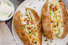 two loaded breads sitting on top of a white plate next to a bowl of yogurt