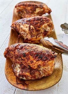 two pieces of chicken on a wooden cutting board