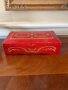 a red box sitting on top of a wooden floor