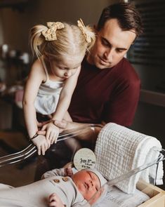 a man and woman are looking at a baby's head in a crib