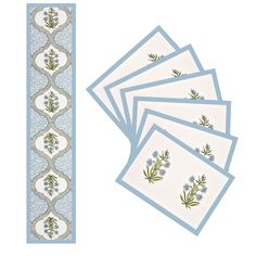 five placemats with blue flowers and green leaves on them, next to a ruler