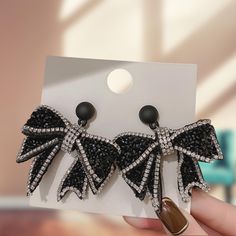 Elevate your style with these captivating Bowknot Design Black Rhinestone Drop Earrings. Featuring a unique bowknot shape embellished with sparkling rhinestones, these earrings are the epitome of elegance and sophistication. Perfect for evening events, parties, or adding a touch of glamour to your everyday look, they make a statement that won't go unnoticed. These luxurious earrings are crafted with high-quality rhinestones that shine brilliantly, ensuring you stand out in any crowd. The bold bl Black Crystal Party Earrings, Glamorous Black Crystal Earrings With Rhinestones, Glamorous Black Crystal Rhinestone Earrings, Elegant Black Crystal Rhinestone Earrings, Elegant Black Crystal Earrings With Rhinestones, Elegant Black Bling Earrings, Black Crystal Earrings For Evening, Black Rhinestone Crystal Earrings For Evening, Black Crystal Earrings With Rhinestones