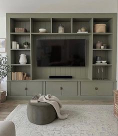 a living room filled with furniture and a flat screen tv on top of a wooden entertainment center