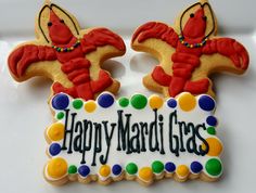 two decorated cookies with the words happy mardi gras on them