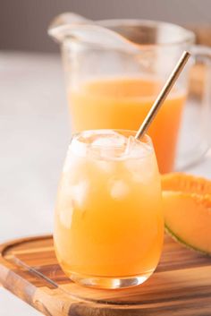 two glasses filled with orange juice on a wooden tray