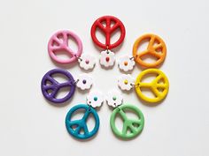 "Add a touch of boho chic to your outfit with these stunning floral peace sign clay earrings. Each earring is carefully handcrafted with love and attention to detail, making them a one-of-a-kind accessory. These earrings are not just about making a fashion statement, but also about comfort and durability. The stainless steel posts ensure that even those with sensitive ears can wear them without any irritation. You can be confident knowing that your new favorite accessory is both hypoallergenic and long-lasting. Whether you're heading out for a casual day with friends or dressing up for a special occasion, these floral peace sign clay earrings are the perfect addition to your ensemble. Get ready to show off your style and spread peace wherever you go! Size: 46 x 30 mm (1.81\" x 1.18\"). You Aesthetic Festival, Floral Peace Sign, Peace Sign Earrings, Peace Earrings, Earrings Clay, Retro Earring, Festival Accessories, Paper Gift Box, Indie Aesthetic