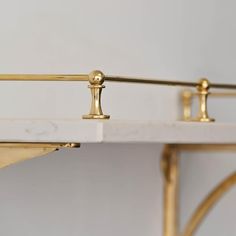 a white marble and gold metal shelf with two handles