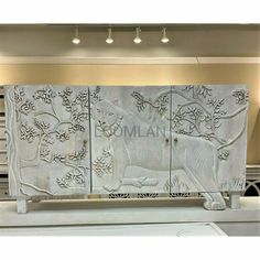 an intricately carved white marble cabinet with lions and flowers on the doors is shown