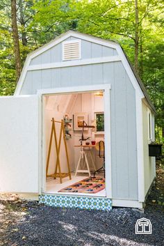 a small shed with the door open and tools in it's storage area inside