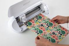 someone using a machine to cut fabric with a flower pattern on the front and side