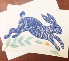 two cards with an image of a running rabbit on one side and leaves on the other