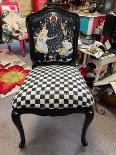 a black and white checkered chair in a room with many other items on the floor