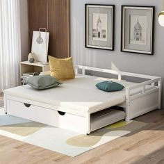 a white bed frame with drawers underneath it in a living room next to a window