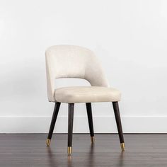 a white chair sitting on top of a hard wood floor next to a white wall