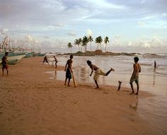 several people are playing on the beach with their surfboards