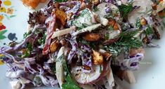 a white plate topped with lots of food on top of a colorful table cloth covered in flowers