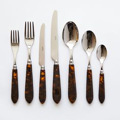 an assortment of silverware with tortoiseshell handles