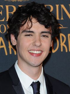 a smiling young man in a suit and tie