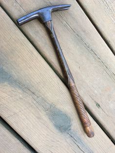 an old hammer and nail are laying on the ground next to some wood planks