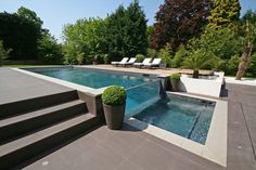 an outdoor swimming pool with steps leading up to it and lounge chairs on the side