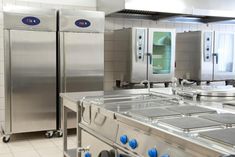 an industrial kitchen with stainless steel appliances and tile flooring on the walls, along with tiled floors