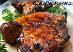 two pieces of meat sitting on top of a cutting board with parsley around it