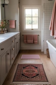 a bath room with a tub a rug and a window