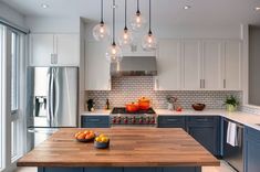 a kitchen with an island and several lights hanging from the ceiling