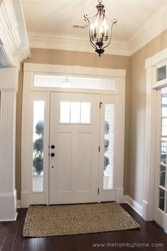 a white door with two windows and a rug on the floor