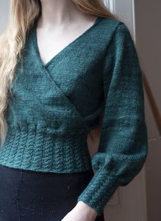 a woman with long blonde hair wearing a green sweater