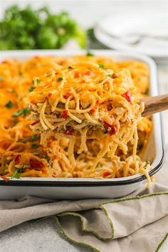 a casserole dish filled with spaghetti and vegetables