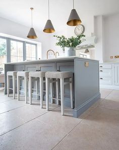 a kitchen island with stools in front of it and a clock on the wall