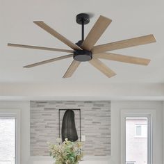 a living room with white couches and a ceiling fan in the middle of it