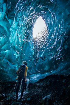 a man standing in front of an ice cave