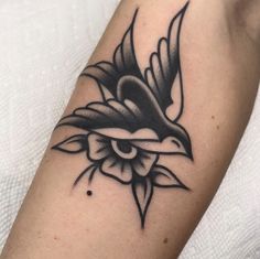 a black and white bird tattoo on the arm