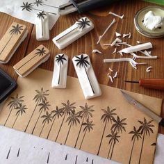 some palm trees are on the table next to scissors and other crafting supplies,