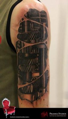 a man with a black and grey tattoo on his arm that has an engine in it